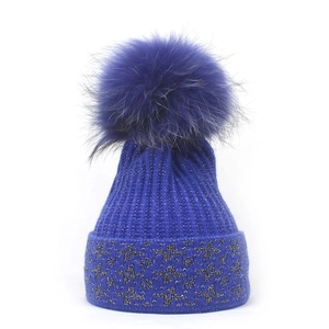 Berretto invernale in maglia blu reale con grande pompon di pelliccia e fili d'argento