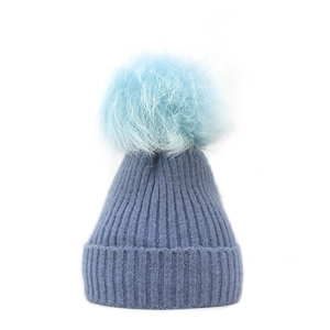Detailed view of the dark blue ribbed knit winter hat with a fluffy light blue pom-pom