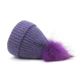 Close-up of deep purple knit beanie with fluffy faux fur pom-pom and ribbed texture