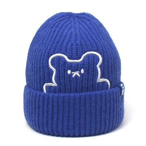 Close-up of Klein blue knit beanie with white bear embroidery and textured ribbed finish