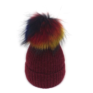 Bonnet d'hiver en tricot côtelé bordeaux avec un pompon en fausse fourrure multicolore