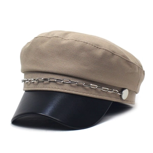 Detailed close-up of khaki newsboy hat featuring a black leather brim and silver chain