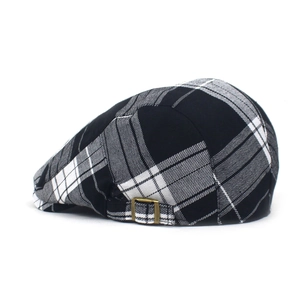 Detail view of adjustable brass buckle on a classic grey plaid duckbill beret hat