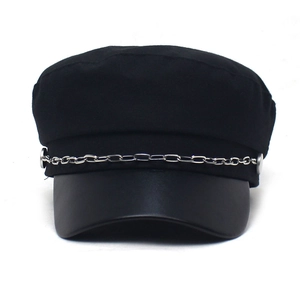 Detail of black newsboy hat featuring leather brim and decorative silver metal chain
