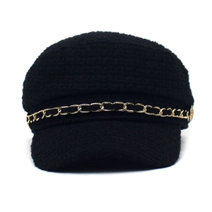Cappello newsboy nero in lana con dettaglio catena dorata su sfondo bianco