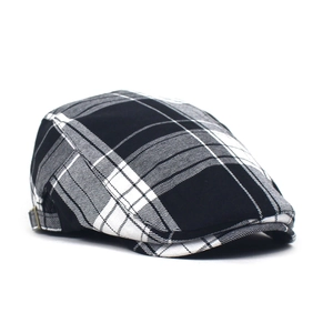 Close-up of black and white plaid flat cap featuring a metallic side adjustment buckle