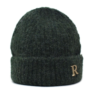 Detail of dark green chunky knit beanie featuring a gold metallic R-letter decoration