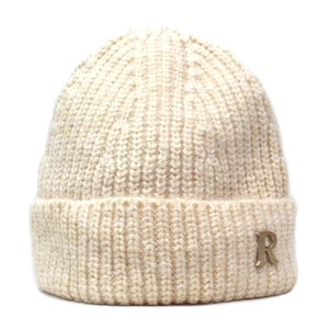 Detail of creamy knit beanie featuring a golden metal R letter pendant and ribbed texture