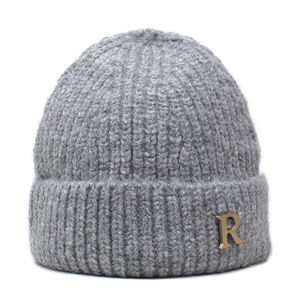 Close-up of grey knit beanie featuring a gold metallic R logo on the folded brim