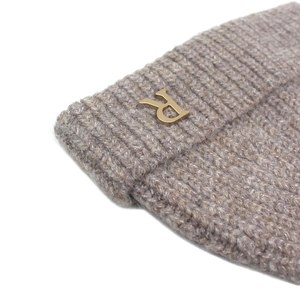 Winter knitted beanie in oat color featuring a premium metal letter R logo decoration