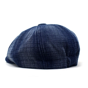 Detailed back view of dark blue denim newsboy cap with refined check stitching patterns