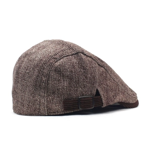 Detail view of brown textured flat cap featuring adjustable metal buckle and warm fabric