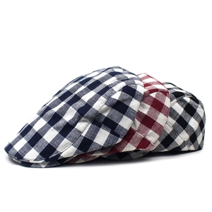 Detailed pile of three plaid flat caps in navy, burgundy, and black cotton-linen textures