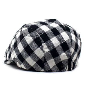 Detailed view of British plaid flat cap with woven texture and side metal buckle