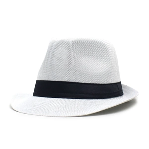 Detail of white woven trilby hat featuring a classic wide black ribbon band decoration