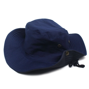 Close-up of a navy wide-brim sun hat with adjustable windproof cord and foldable metal buttons