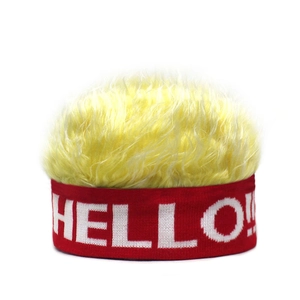 Détail du bonnet rouge avec texte HELLO blanc et faux cheveux jaunes duveteux