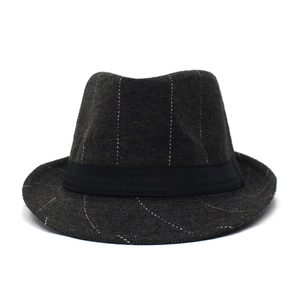Detailed macro view of dark grey herringbone fabric and black ribbon on a classic fedora hat