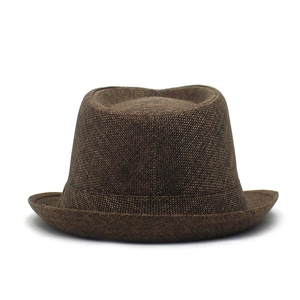 Close-up of the woven linen texture and curved brim of the dark brown fedora hat