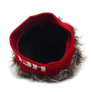 Détail du bandeau rouge en tricot avec perruque de faux cheveux et lettrage blanc