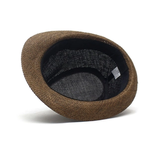 Vue détaillée de l'intérieur d'un chapeau en paille marron avec bandeau et étiquette de taille