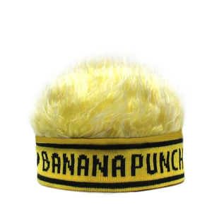 Detail van gele gebreide muts met pluizig imitatiebont en BANANA PUNCH borduursel