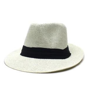Détail de la texture en paille de papier et du ruban noir sur le chapeau Panama beige