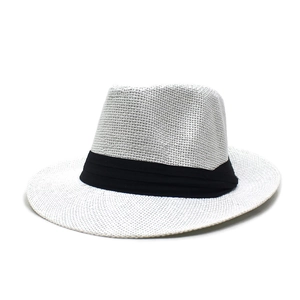 Détail d'un chapeau en paille de papier blanc avec un élégant ruban noir décoratif