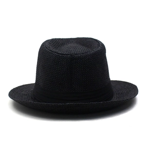 Détail de la texture tressée et du ruban noir sur ce chapeau de paille élégant pour l'été