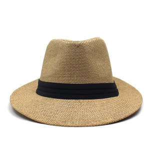 Close-up of the woven straw texture and decorative black ribbon on a summer sun hat