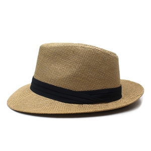 Close-up of a woven straw sun hat with a black band and breathable mesh texture