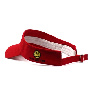 Detail of red sun visor with yellow smiley face embroidery and adjustable metal buckle