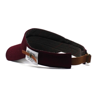 Detail view of burgundy cotton sun visor showing the adjustable leather strap and plaid lining