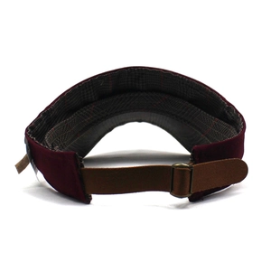 Detail of burgundy sun visor with brown leather strap and bronze metal buckle