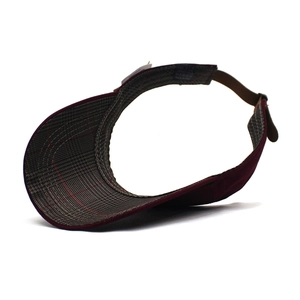 Detail view of the adjustable strap and grey plaid brim lining of the sun visor