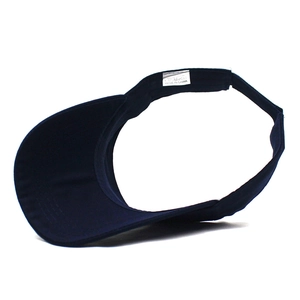 Detail view of navy blue cotton sun visor with white washing label and curved brim