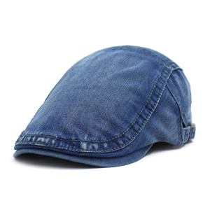 Détail du béret en denim bleu délavé montrant la boucle métallique et les coutures