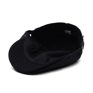 Detail view showing 100% cotton material and metal adjustment buckle on the black beret