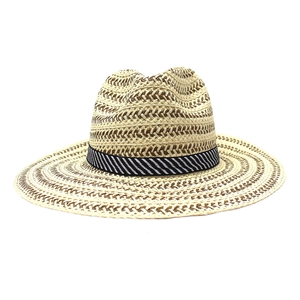 Detail of hand-woven straw sun hat texture with black and white striped ribbon band