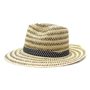 Close-up of wide-brim straw hat featuring detailed herringbone weave and striped band
