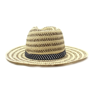 Close-up of the intricate zigzag straw weave texture and black striped ribbon on sun hat