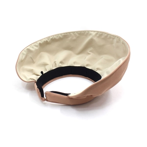 Detail view of foldable sun hat featuring wide pink brim and breathable pleated fabric