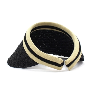 Detail of woven straw sun visor featuring a black brim and striped breathable headband