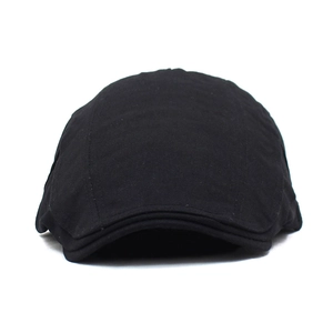 Détail de la casquette plate en coton noir montrant les coutures et la texture du tissu
