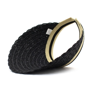 Detail view of woven paper straw sun hat with black brim and interior beige sweatband