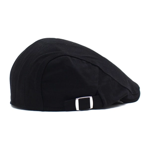 Détail de la boucle réglable en argent sur la casquette newsboy en coton noir uni