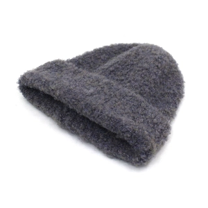 Detail of dark grey-blue knit beanie featuring thick curly wool texture and folded cuff