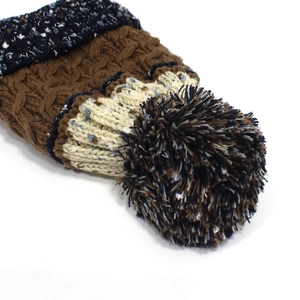 Détail de maille torsadée et pompon doux sur le bonnet d'hiver multicolore tricoté