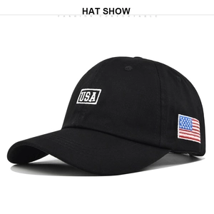 Detailed close-up of USA embroidery and American flag patch on a black cotton baseball cap