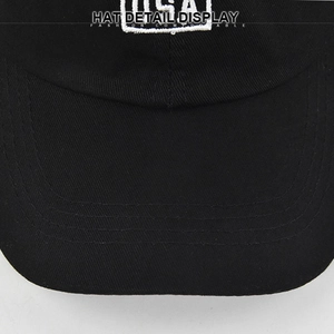 Close-up of black cotton baseball cap with curved brim stitching and white embroidery